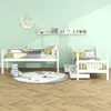 A children's bedroom with two white wooden beds, a round rug, and wall decorations. Náhľad obrázku produktu