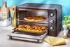 A toaster oven with food inside, set on a kitchen counter. Voir les images du produit