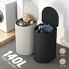 Two laundry baskets, one white and one black, are shown in a room with a washing machine in the background. The white basket contains stuffed animals, and the black basket contains laundry. Text indicating capacity and clothing types is present. Produktbild-Vorschau