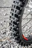 A close-up of a motorcycle tire on a gravel surface. Náhľad obrázku produktu