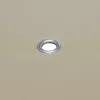 A close-up of a beige fabric with a metal grommet. Voir les images du produit