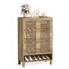 A wooden shoe cabinet with slatted doors and an open shelf at the bottom, displaying shoes. Decorative items are placed on top. Produktbild-Vorschau