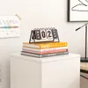 A white cabinet with books and a desk calendar on top. Náhled obrázku produktu