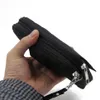 A hand holds a black travel bag with zippers. Produktbild-Vorschau