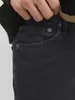 A close-up shot of a person's hand reaching into the pocket of dark wash jeans. Produktbild-Vorschau