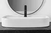 A white vessel sink with a black faucet is shown on a dark countertop, with a circular mirror in the background. Produktbild-Vorschau