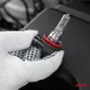 A gloved hand holding a car headlight bulb. Podgląd zdjęcia produktu