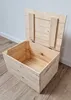 A wooden chest with its lid open, placed on a wooden floor against a white wall. Náhled obrázku produktu