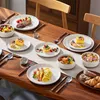 A beautifully set dining table with various dishes and tableware, suggesting a meal or gathering. Produktbild-Vorschau