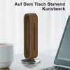 A wooden headphone stand is placed on a desk next to a laptop and a cup of coffee. Produktbild-Vorschau