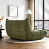 A green beanbag chair is placed on a rug in a living room with a window and a floor lamp. Produktbild-Vorschau