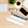 A desk setup with a keyboard, glasses, coffee, phone, and a stylus case. Produktbild-Vorschau