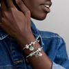 A close-up shot of a person's arm wearing two Pandora charm bracelets. Anteprima dell’immagine prodotto