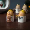 A close-up shot of three ceramic angel figurines playing musical instruments, arranged on a wooden surface. Produktbild-Vorschau