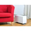 A white humidifier sits on a wooden floor next to a red armchair, with a curtain in the background. Produktbild-Vorschau
