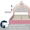A pink bed frame with a cloud-shaped headboard featuring LED lights and a crown detail. The image also includes diagrams and text indicating adjustable height and mattress compatibility. Náhľad obrázku produktu