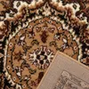 A close-up view of a rug, showing its intricate pattern and texture, with a corner flipped over to reveal the backing. Produktbild-Vorschau