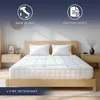 A mattress on a bed with pillows, in a bedroom setting. Anteprima dell’immagine prodotto