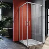A modern bathroom with a glass shower enclosure, a red accent wall, and wooden flooring. Voir les images du produit