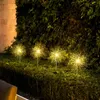 Solar-powered dandelion-shaped lights are illuminating a garden at night. Produktbild-Vorschau