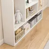 A white bookshelf filled with various items, including decorative figures, books, and storage boxes, placed on a wooden floor. Náhľad obrázku produktu