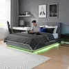 A teenage boy is sitting on a bed in a modern bedroom, looking at his phone. The bed has LED lighting underneath. Produktbild-Vorschau
