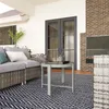 An outdoor patio setting with furniture and a brick fireplace. Produktbild-Vorschau