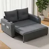 A gray sofa bed is shown in a living room setting with a plant in the background. Voir les images du produit