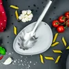 A top-down view of ingredients and a pasta server on a dark gray surface. Produktbild-Vorschau