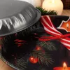 A close-up of a Christmas-themed metal plate with a lid partially covering it, decorated with pine branches, ornaments, and candles. Produktbild-Vorschau