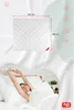 A woman is stretching in bed, with a product image of a blanket above. Produktbild-Vorschau