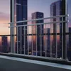 A balcony railing in front of a blurred cityscape at dusk. Produktbild-Vorschau