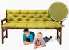 Two young boys are lying under a wooden bench with a green cushion. Produktbild-Vorschau