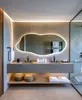A modern bathroom vanity with a large, illuminated mirror, double sinks, and storage shelves. Produktbild-Vorschau