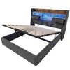 A bed frame with its mattress support lifted, showing the storage space underneath. The headboard features integrated lighting and small drawers. Produktbild-Vorschau