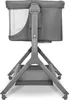 A gray baby bassinet with a mesh window on the side, shown from the back with its adjustable legs and a storage basket underneath. Produktbild-Vorschau