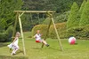 Two children are playing in a garden with a wooden swing set and a beach ball. Produktbild-Vorschau