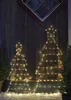 Two illuminated Christmas tree silhouettes with stars on top, placed outdoors against a wooden wall. Podgląd zdjęcia produktu