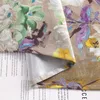 A close-up of a fabric with a floral oil painting pattern, folded to reveal the lining and some text underneath. Produktbild-Vorschau