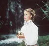 A young girl in historical clothing holds a golden orb in a natural setting with a waterfall in the background. Náhled obrázku produktu