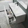 A modern bathroom vanity with an open drawer displaying various cosmetic items. Produktbild-Vorschau