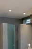 A modern bathroom with gray tiled walls and frosted glass shower doors. Produktbild-Vorschau