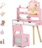 A pink wooden children's vanity set with a mirror, chair, and various toy makeup accessories. Podgląd zdjęcia produktu