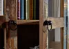 A close-up view of a wooden cabinet with two black ring handles, showing the texture and wear of the wood. Anteprima dell’immagine prodotto
