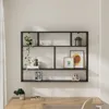 A black metal wall shelf with multiple compartments, decorated with plants, picture frames, and decorative objects, mounted above a wooden desk. Anteprima dell’immagine prodotto