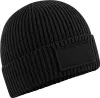 A black beanie with a patch on it, shown from a diagonal angle. Anteprima dell’immagine prodotto