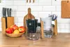 Two water filter pitchers are displayed on a kitchen counter next to a fruit bowl and a knife block. Podgląd zdjęcia produktu