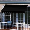 A black awning is installed above a set of glass doors on a house, with a white railing in the foreground. Anteprima dell’immagine prodotto