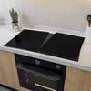 A kitchen countertop with a black glass stovetop cover and an oven below. Produktbild-Vorschau