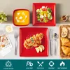 A table setting with red square plates filled with food, including soup, salad, and pasta, along with bread and croissants on a wooden tray. Náhled obrázku produktu